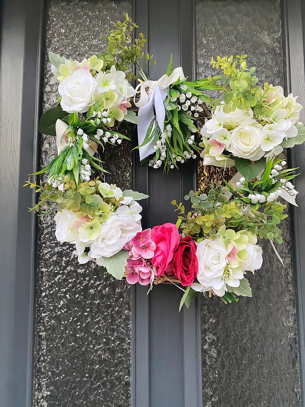 La couronne de roses, d’hortensias et de muguet sur la porte d’entrée de Chez Patou