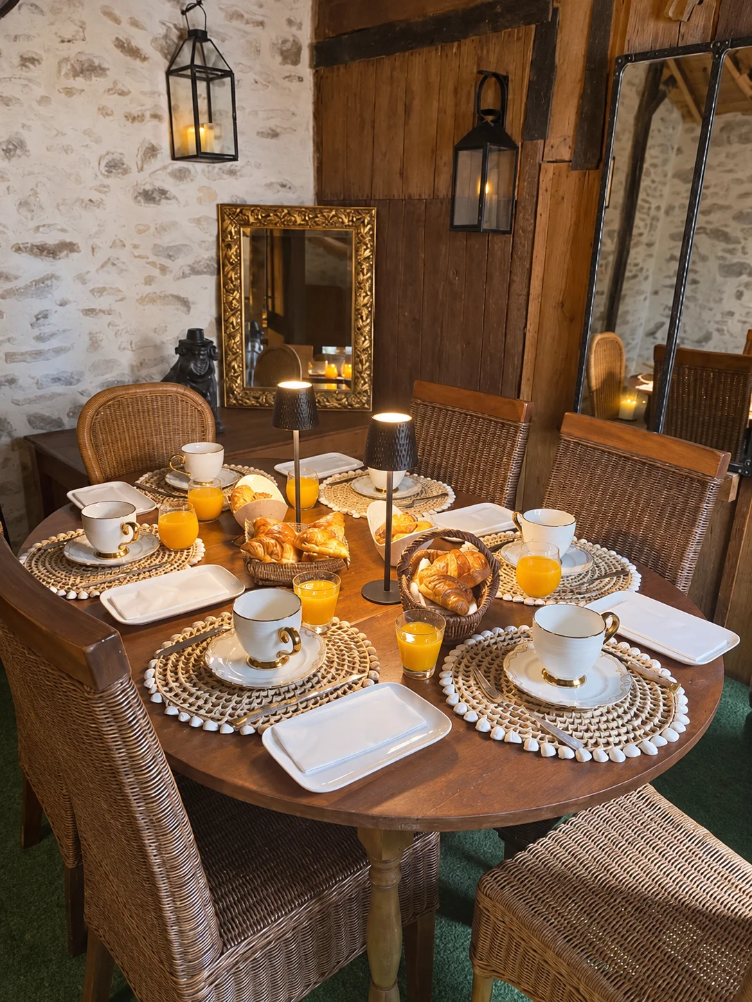 Le petit-déjeuner dressé autour de la table ronde, devant les murs en pierre et les miroirs